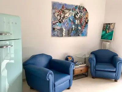 two blue chairs in a room with a painting at Gallery Guesthouse in Rome
