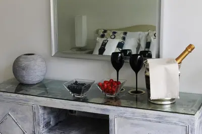 a table with some wine glasses and a mirror at Gallery Guesthouse in Rome