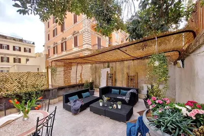 an outdoor patio with black furniture and a wooden ceiling at Scipioni Terrace in Rome