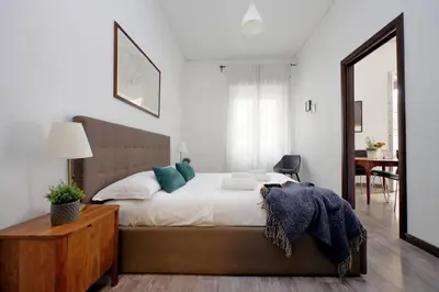 a bedroom with a bed and a chair and a mirror at Scipioni Terrace in Rome