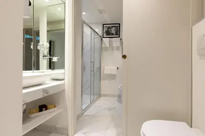 a white bathroom with a shower and a sink at Piazza di Spagna Moda Luxury Apartment in Rome