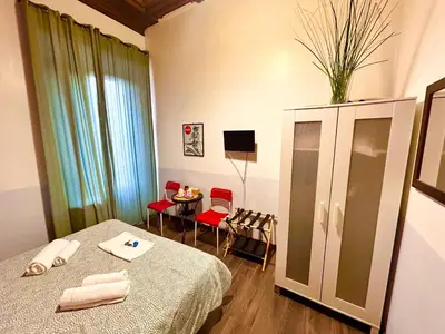 a room with a bed and a table with chairs at Core De Roma Suites in Rome
