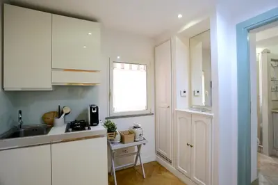 a kitchen with white cabinets and a sink and a window at Maddalena 6 - Pantheon in Rome