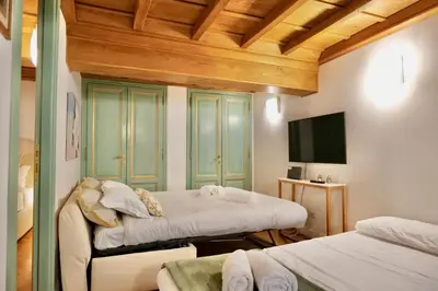 a bedroom with two beds and a flat screen tv at Maddalena 6 - Pantheon in Rome