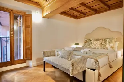 a bedroom with a bed and a chair and a window at Maddalena 6 - Pantheon in Rome
