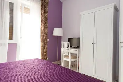 a bedroom with a purple bed and a desk at Parco Delle Valli in Rome
