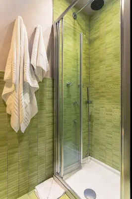 a bathroom with a shower with green tiles at Moai Home in Rome