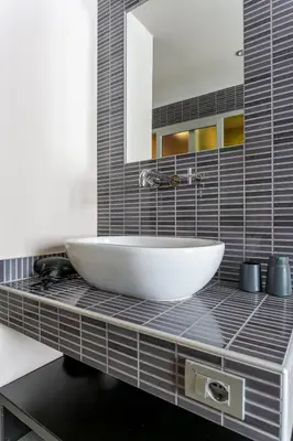 a bathroom with a white sink and a mirror at Moai Home in Rome