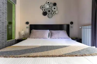 a bedroom with a large bed and a clock on the wall at Moai Home in Rome
