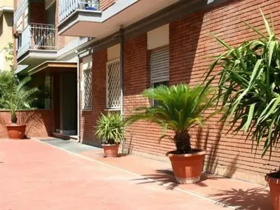 a group of potted plants in front of a brick building at Le Fate Apartments in Rome
