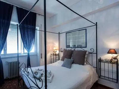 a bedroom with a white bed with a metal canopy at Le Fate Apartments in Rome