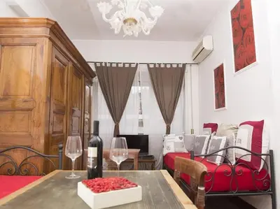 a room with a table with wine glasses and a couch at Le Fate Apartments in Rome