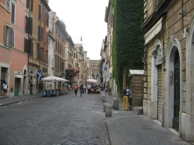 a cobblestone street with people walking down the street at Vatican Color House in Rome