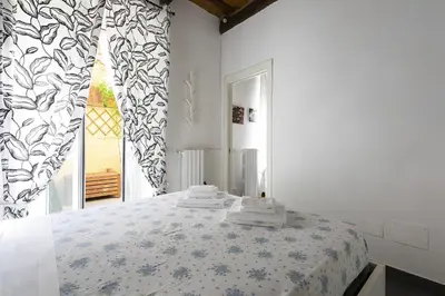 a bedroom with a bed and a window with curtains at Emma's Apartment Borgo, Vatican City in Rome
