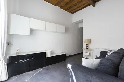 a living room with a couch and white walls at Emma's Apartment Borgo, Vatican City in Rome