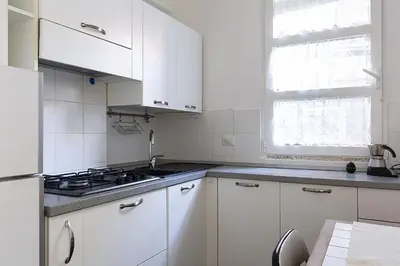 a white kitchen with white cabinets and a sink at Emma's Apartment Borgo, Vatican City in Rome