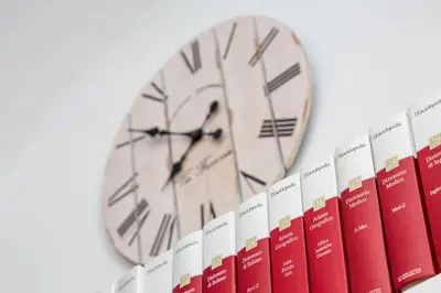 a clock sitting on top of a row of books at L’ARTSHOP in Rome