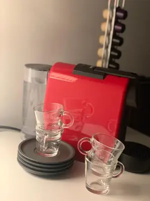 two glasses sitting on a table next to a red box at L’ARTSHOP in Rome