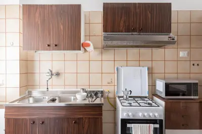 a kitchen with a sink and a stove top oven at Hortis Apartment, 5 persone, 2 camere, balcone, Metro C per il Colosseo a 10 minuti e tram per Termini a 2 minuti in Rome