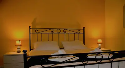a bedroom with a bed with white sheets and two lamps at Rhome202 in Rome