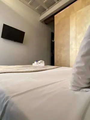 a bed with a pillow and a tv on the wall at Nerva Accommodation in Rome