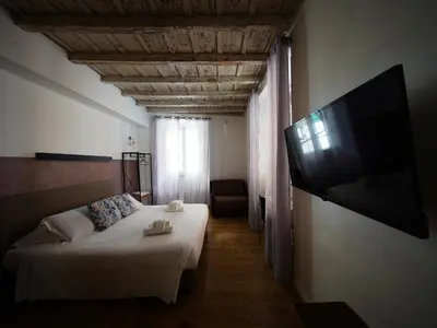 a bedroom with a bed and a flat screen tv at Nerva Accommodation in Rome