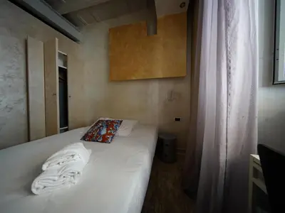 a bed with white sheets and a pillow on it at Nerva Accommodation in Rome