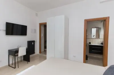a bedroom with a bed and a desk and a television at San Pietro Home in Rome