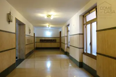 an empty hallway of a building with wooden walls and windows at Come a Casa in Rome