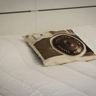 a camera sitting on top of a book on a bed at VaticanArt in Rome
