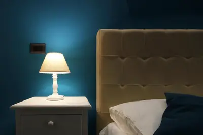a lamp on a night stand next to a bed at Vatication B&B in Rome