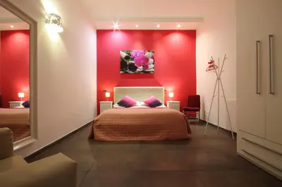 a bedroom with red walls and a bed with purple pillows at Vatication B&B in Rome