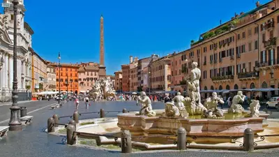 a fountain in the middle of a city with buildings at Vatication B&B in Rome