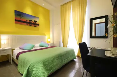 a bedroom with a bed and a desk and a window at Vatication B&B in Rome