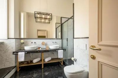 a bathroom with two sinks and a mirror at Spagna Luxury Rooms in Rome