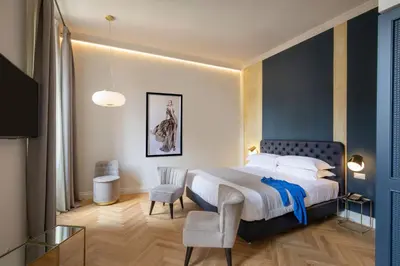 a bedroom with a large bed and a chair at Spagna Luxury Rooms in Rome