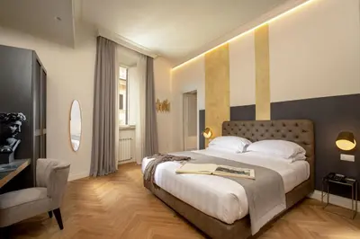 a bedroom with a large bed and a television at Spagna Luxury Rooms in Rome
