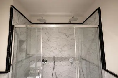 a bathroom with a shower with a glass door at Spagna Luxury Rooms in Rome
