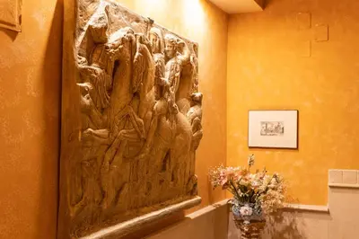 a wall art in a room with a vase of flowers at Classic Flat Monti in Rome