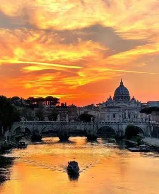 a bridge and a boat on a river with a sunset at ROMAN DREAM I in Rome
