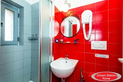 a red bathroom with a sink and a mirror at Dream Station 2 in Rome