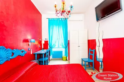 a red bedroom with a red bed and blue chairs at Dream Station 2 in Rome