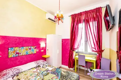 a bedroom with pink walls and a desk and a bed at Dream Station 2 in Rome