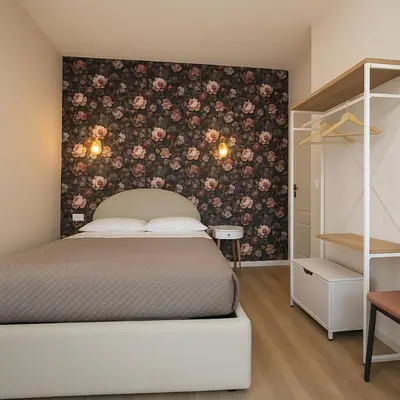 a bedroom with a bed with a floral wall at B&B Aurelia Garden Rooms in Rome
