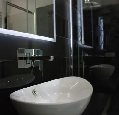 a bathroom with a white sink and a mirror at B&B Aurelia Garden Rooms in Rome