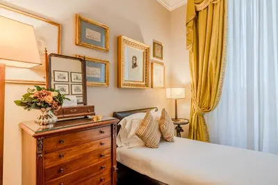 a bedroom with a bed and a dresser with a mirror at Colonna Traiana - The View Boutique Luxury Home in the center of ancient Rome in Rome