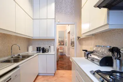 a kitchen with white cabinets and a sink at Colonna Traiana - The View Boutique Luxury Home in the center of ancient Rome in Rome