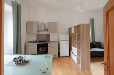 a kitchen with a refrigerator and a kitchen with a couch at Trastevere Heart Home in Rome