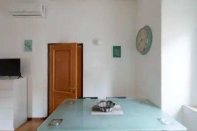 a room with a glass table and a clock on the wall at Trastevere Heart Home in Rome