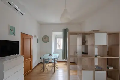 a living room with a table and a dining room at Trastevere Heart Home in Rome